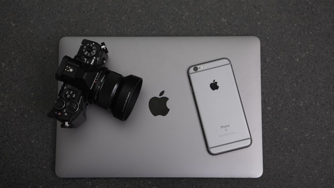 camera and an iphone sitting on a laptop