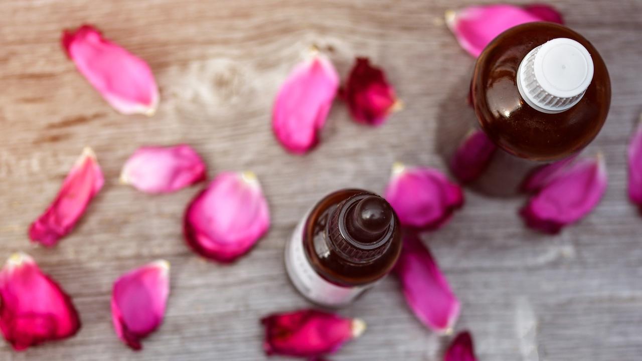 essential oil bottle with rose petals