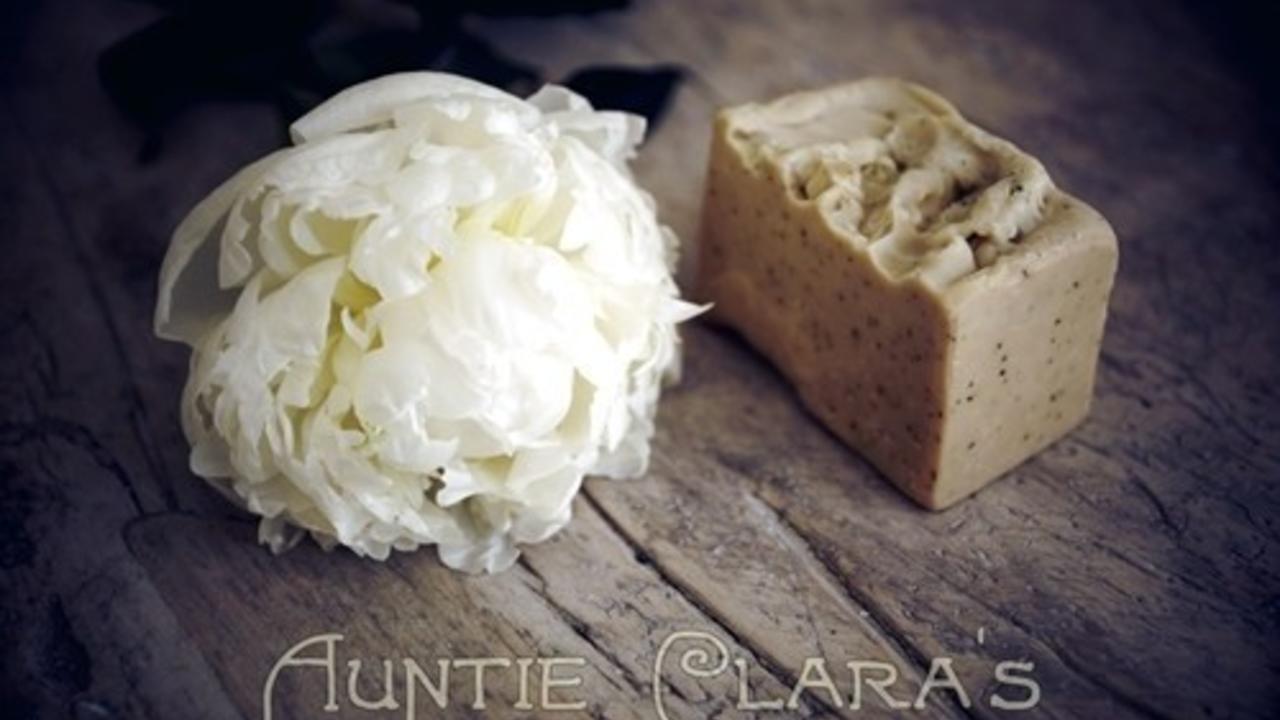 brown bar of soap next to a peony