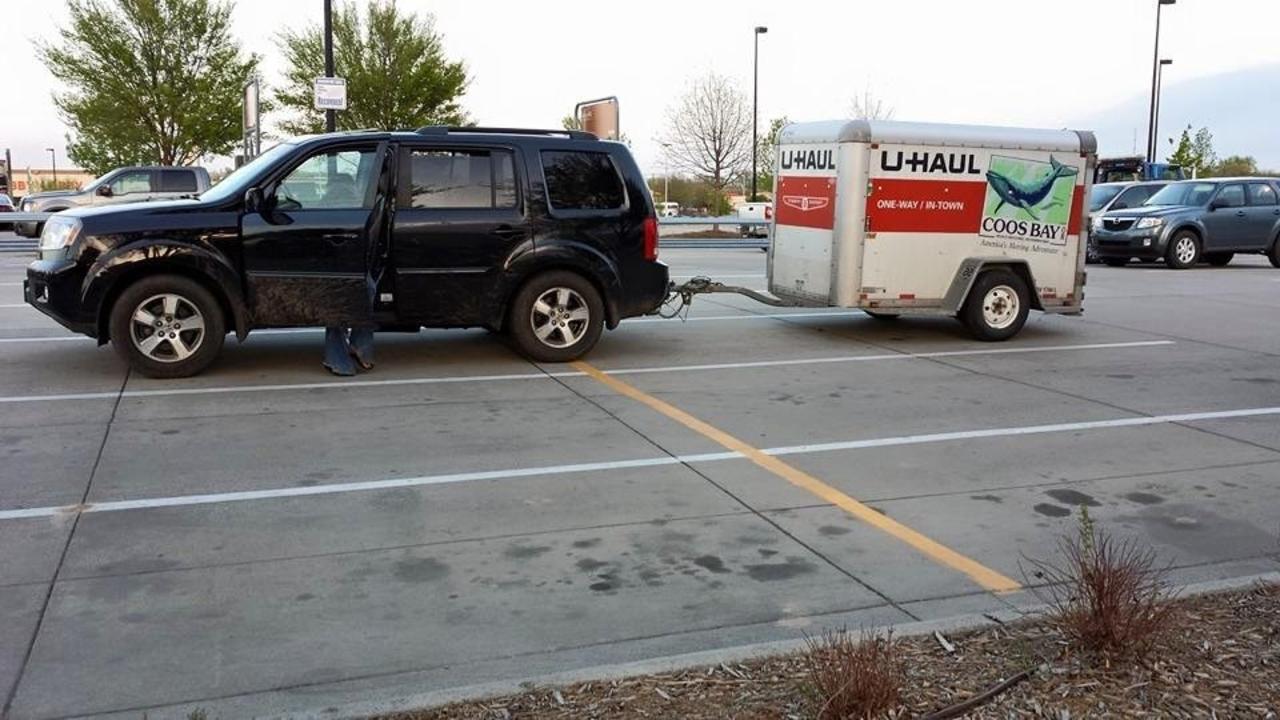 car and uhaul trailer in a parking lot